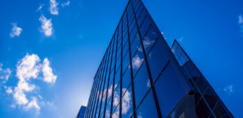 Abstract architecture background with blue sky and modern office building with reflection in the window glass
