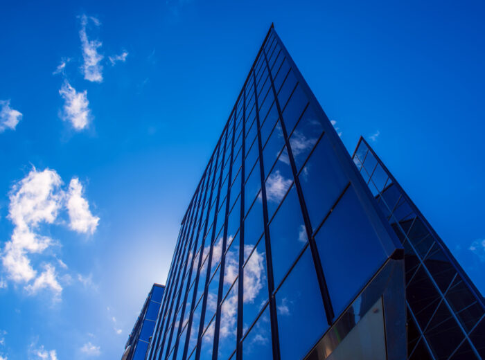 Abstract architecture background with blue sky and modern office building with reflection in the window glass
